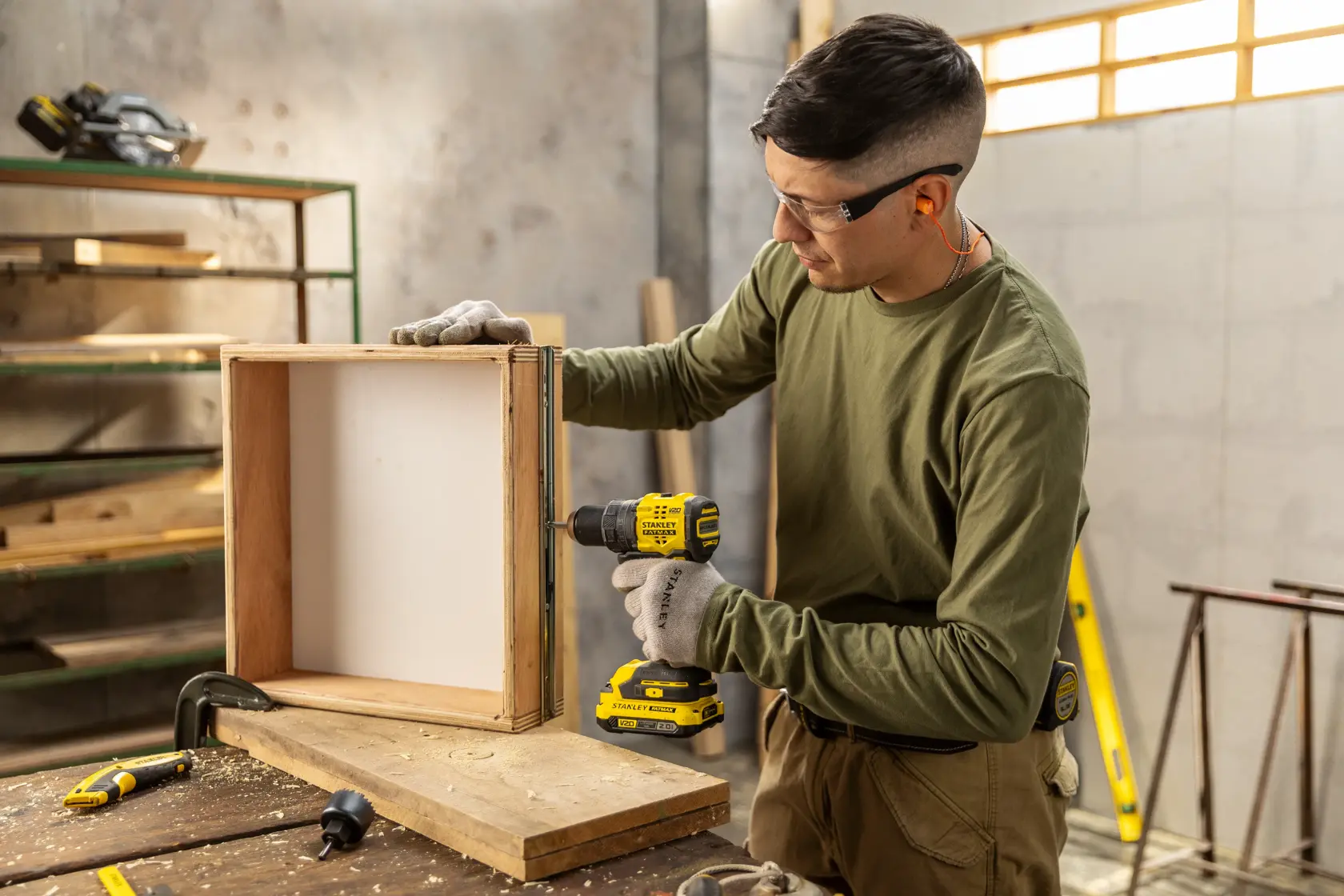 Taladro inalámbrico STANLEY SBD714 usado para ensamblar una caja de madera en un taller.
