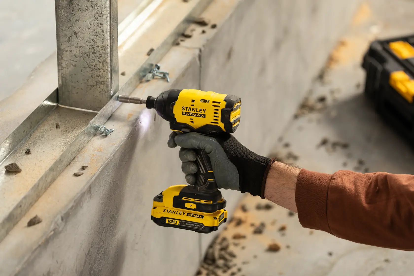 Fotografía de un atornillador de impacto inalámbrico STANLEY FATMAX V20, SKU SBI801, usado para fijar un marco metálico.