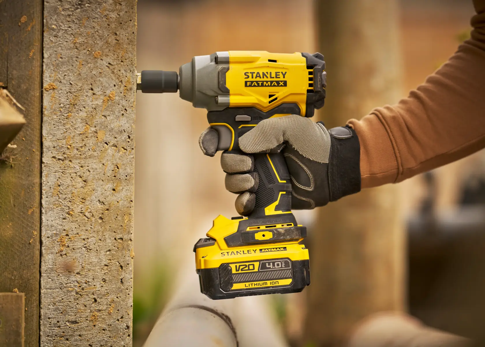 Stanley SBW920M2K atornillador de impacto inalámbrico en uso, amarillo y negro, toma lateral cercana.