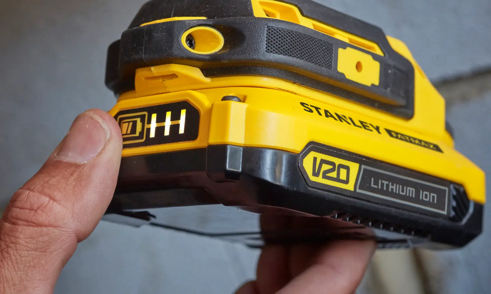 Stanley SCD711C2K-BR batería de ion de litio V20 en primer plano, carcasa amarilla y negra, indicador de carga.