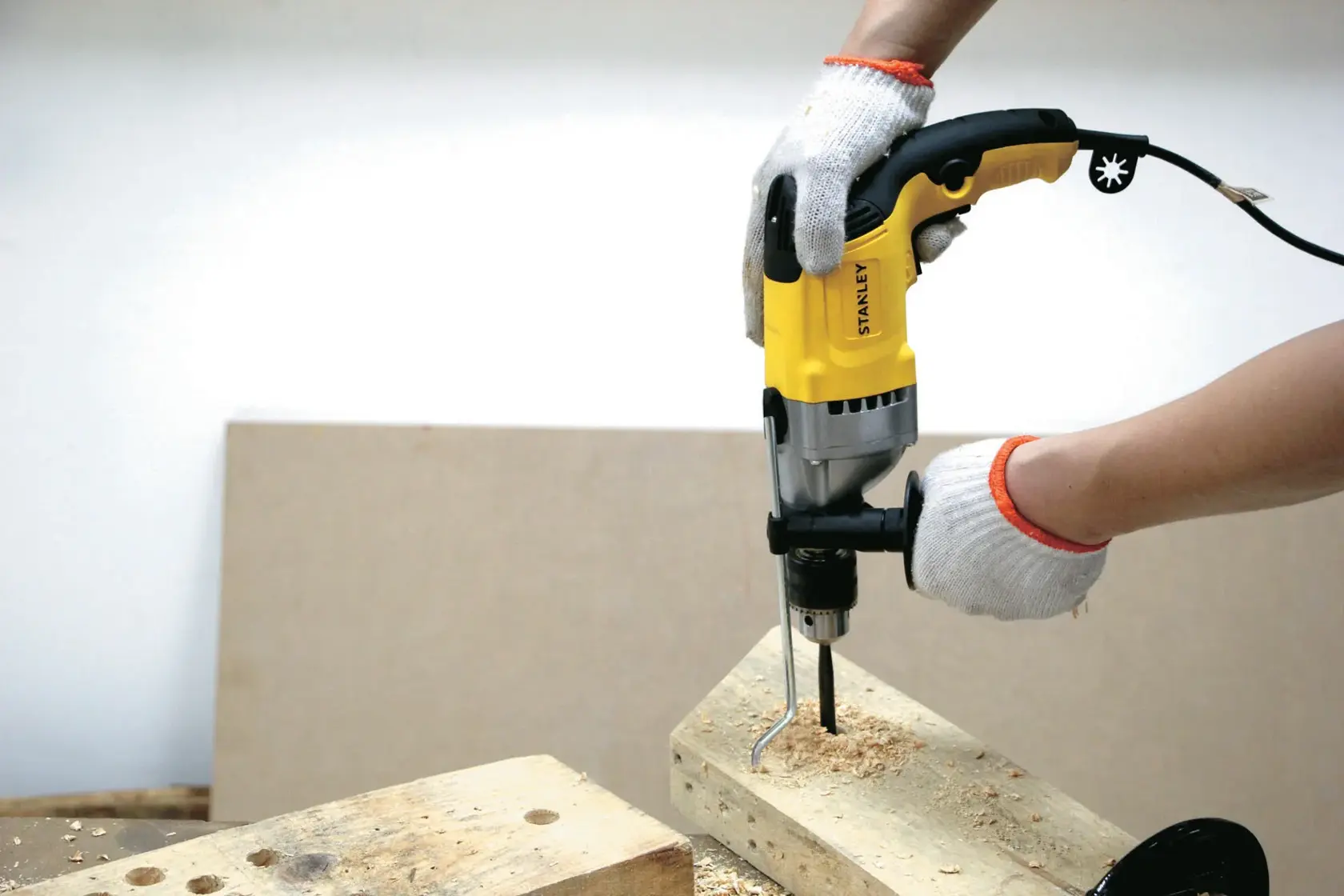 STANLEY STDH8013 fotografía de taladro con cable amarillo en uso perforando madera.
