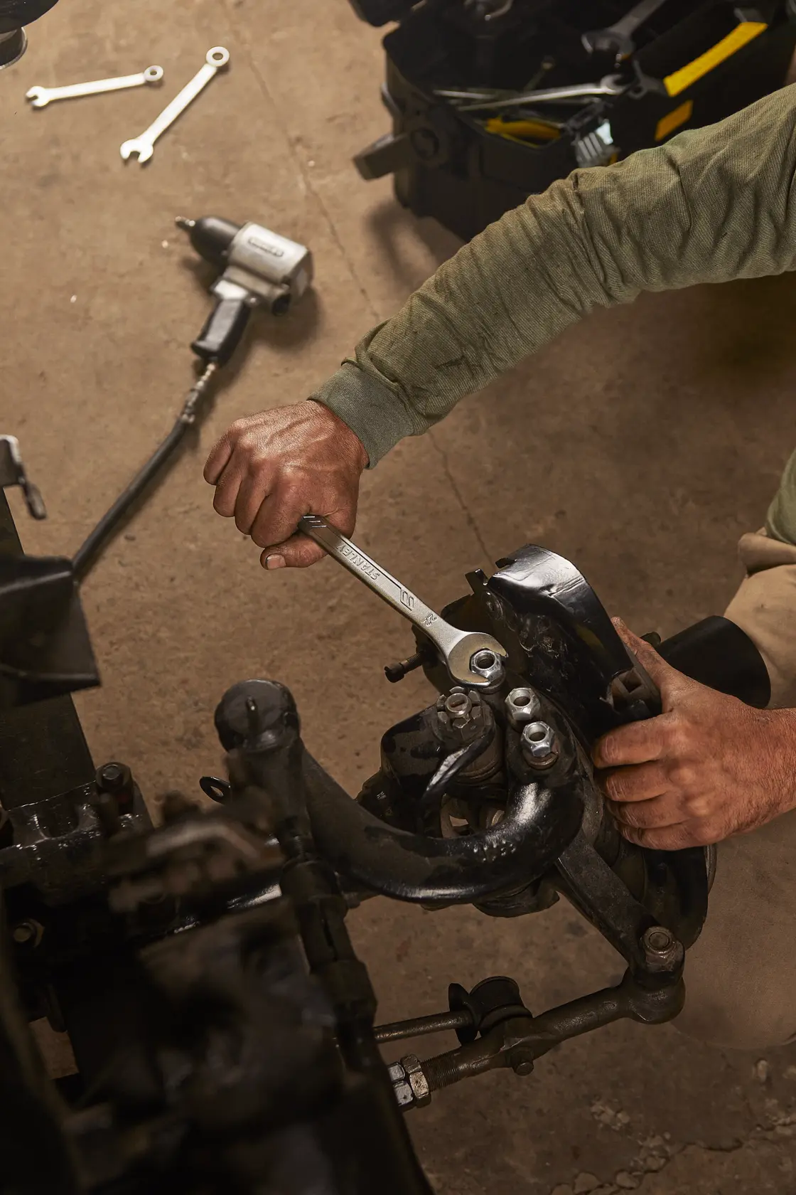 Llave STANLEY STMT72819 en uso sobre parte automotriz en taller, vista cenital.