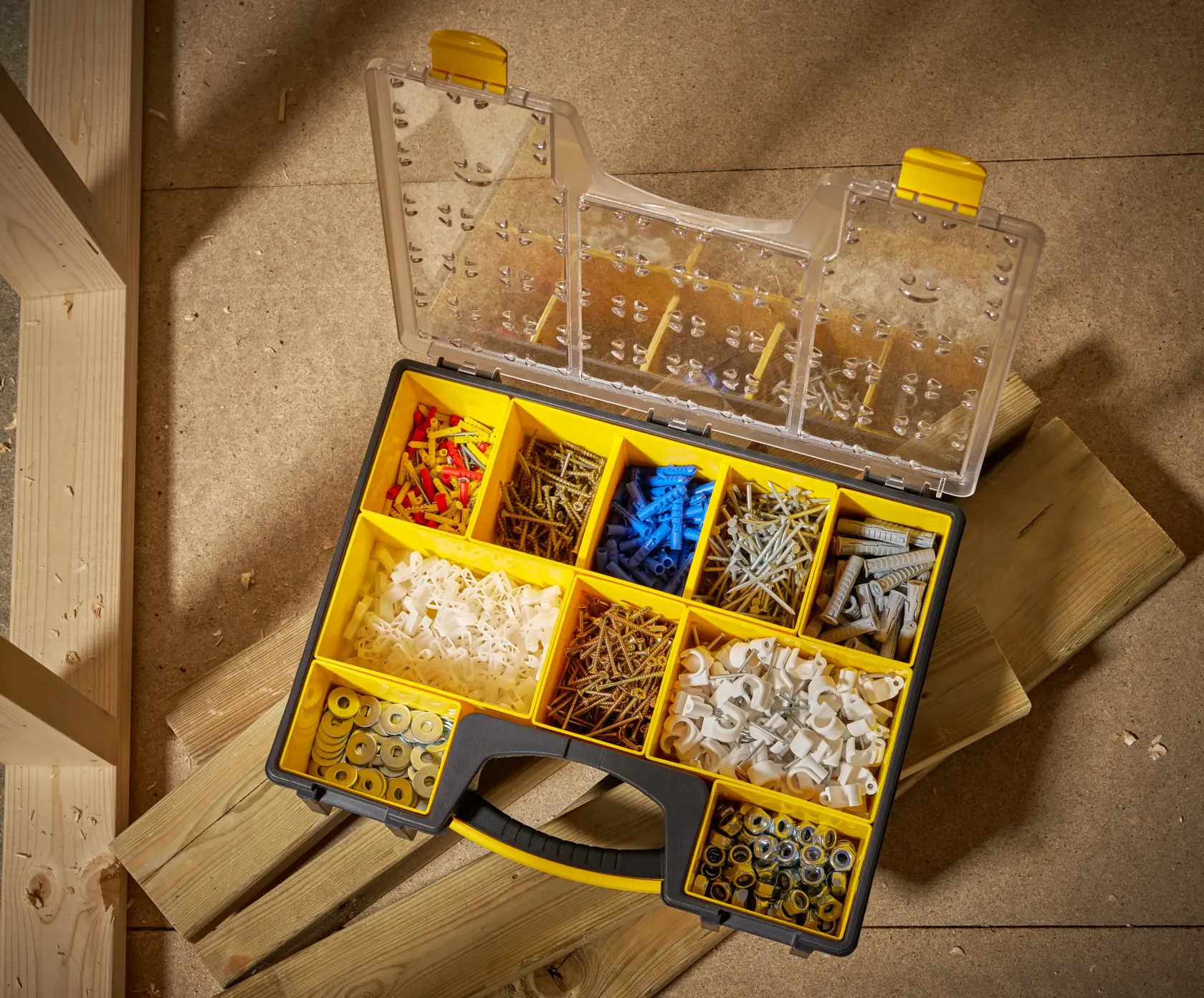 STANLEY STST14710 caja organizadora con compartimentos amarillos llenos de sujetadores variados, vista superior.